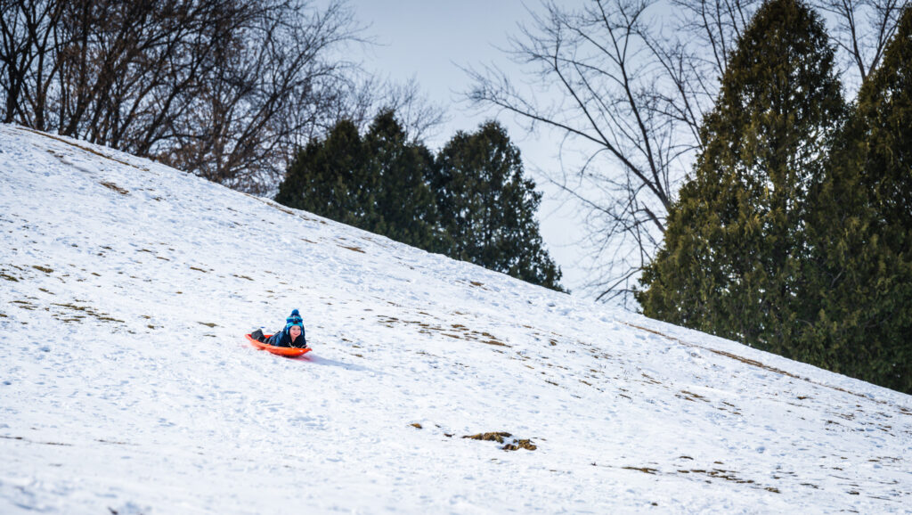 Sledding down the hill at Plamann County Park after a snowstorm.