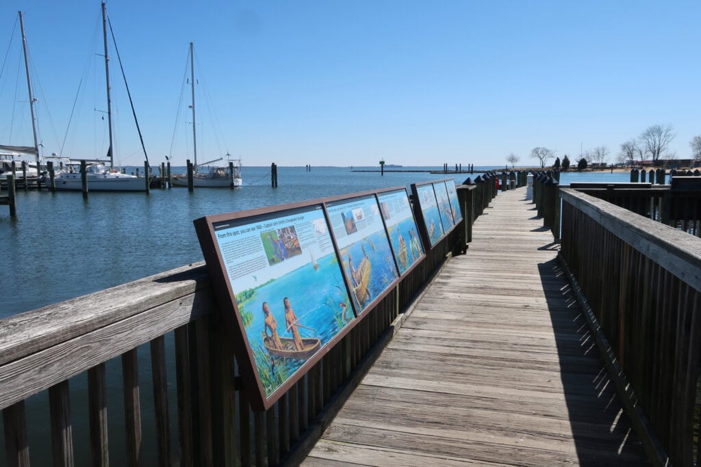 Boardwalk lined with information panels juts into cove Eastport cove