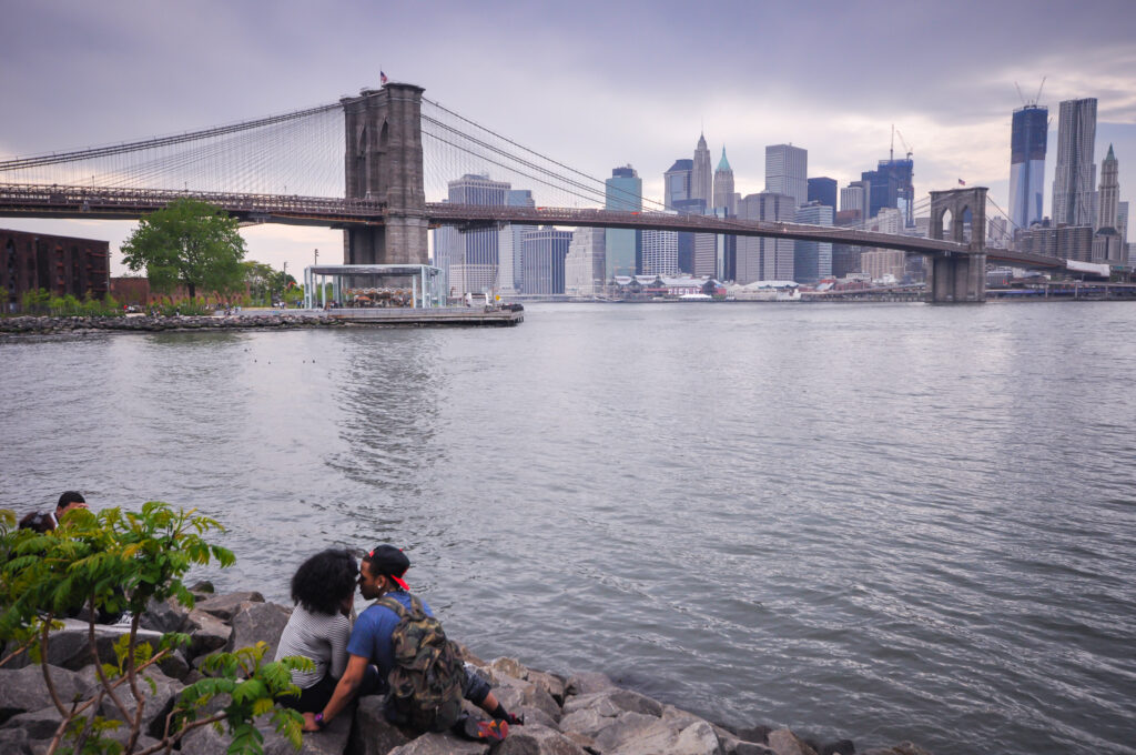 Couple enjoys a romantic moment in front of the Brooklyn Bridge