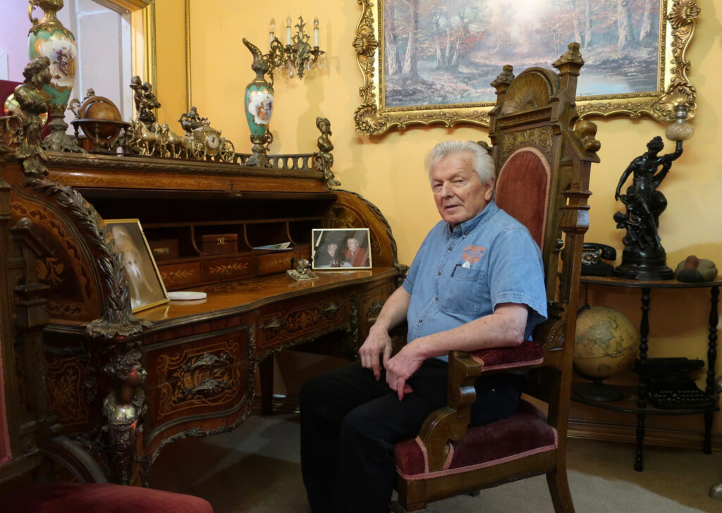 Bill Morris sitting at 1800s carved French desk at Bills Bike Barn Bloomsburg Pa