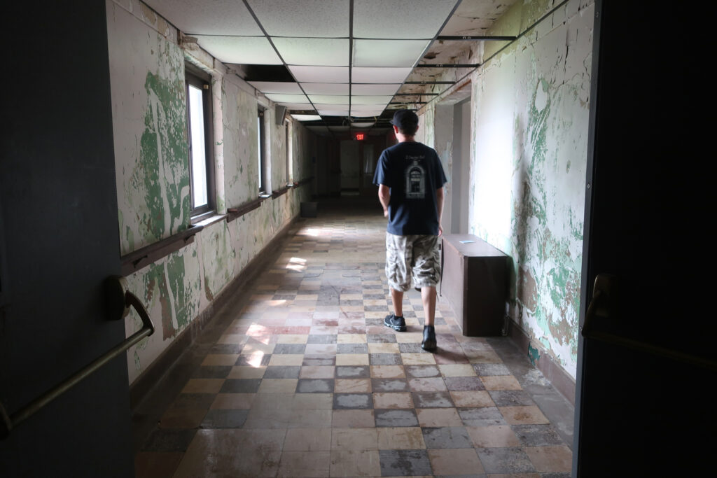 Donnie Graham walks down abandoned nursing home hallway at Haunted Hill View Manor, New Castle PA