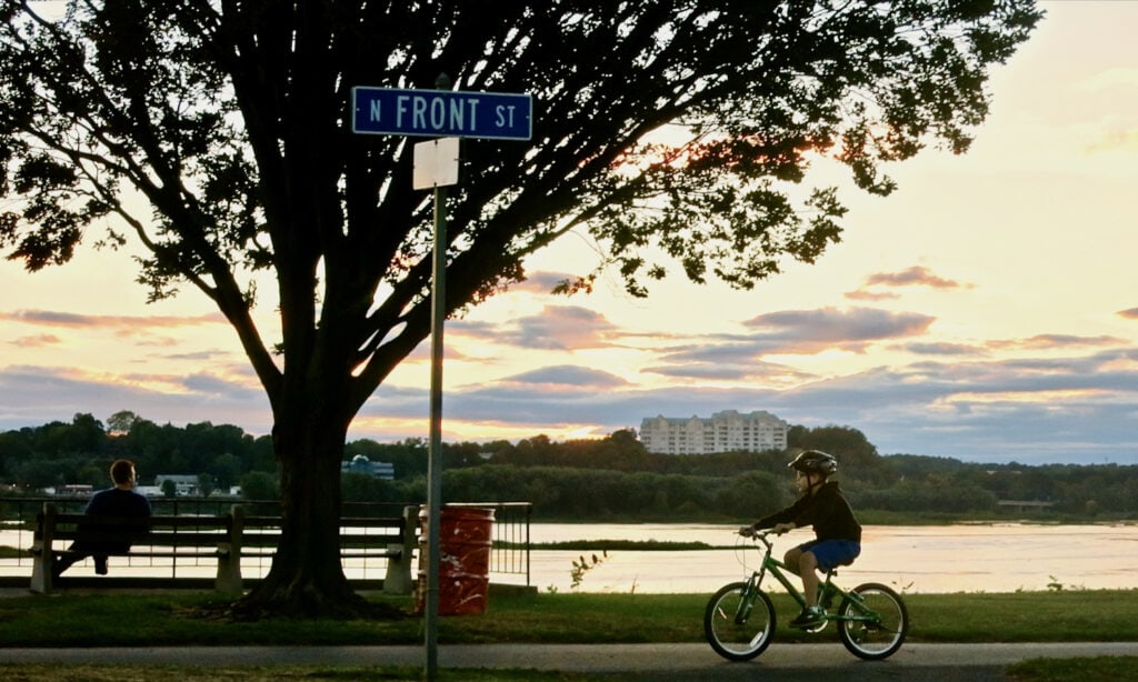 Kid riding bike along Front St. Harrisburg PA
