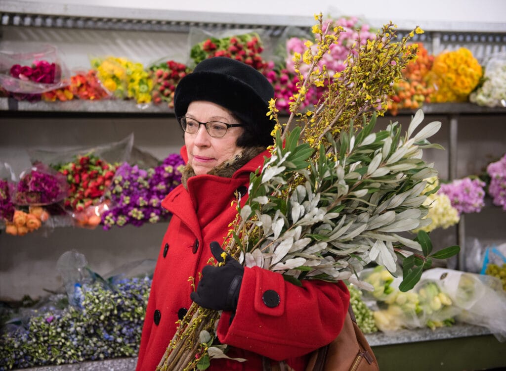 Woman holding bunch of greenery in Chelsea Flower Market