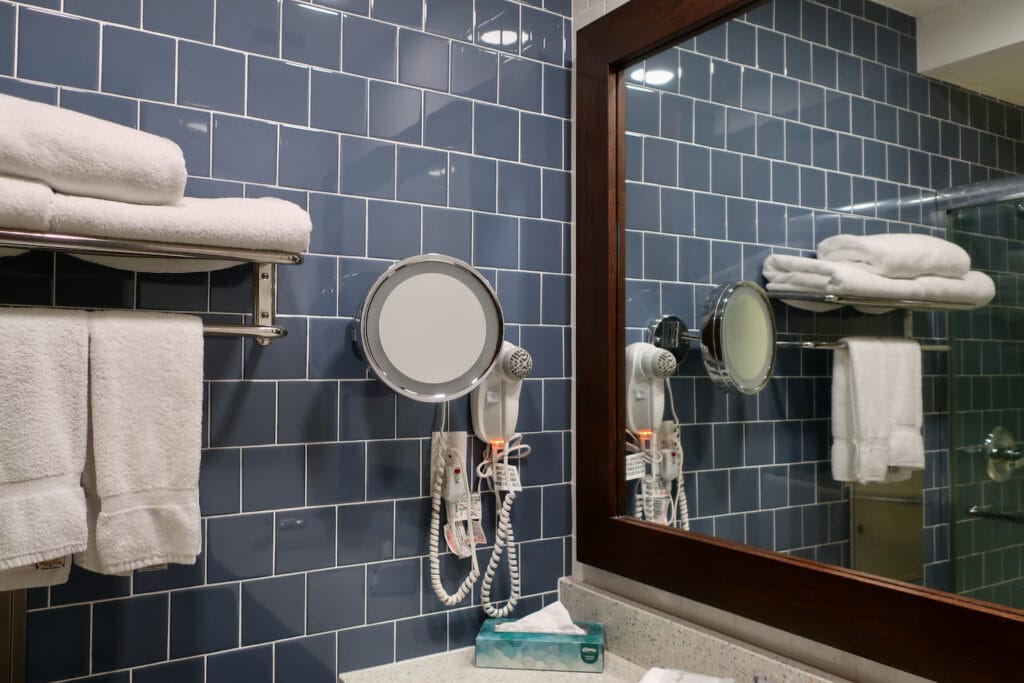 Renovated bathroom at Hotel UMass in smokey-blue subway tile.